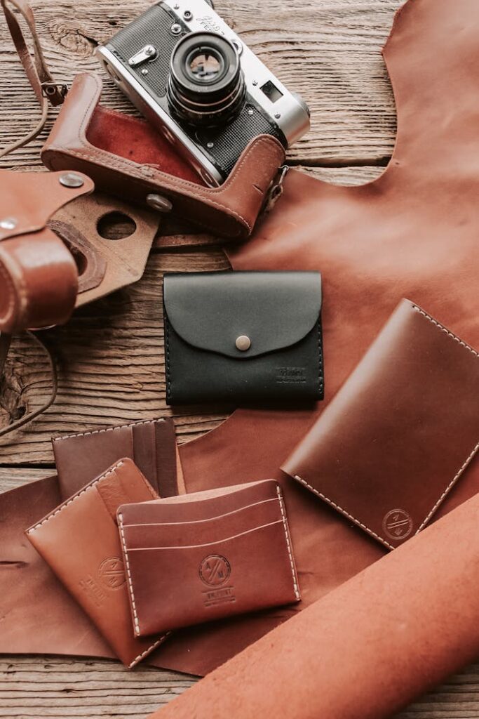 Artistic display of handcrafted leather wallets and vintage camera.